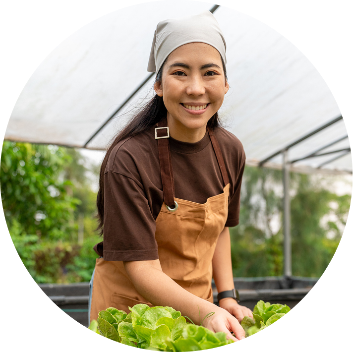 Farmer in apron cultivating green vegetables