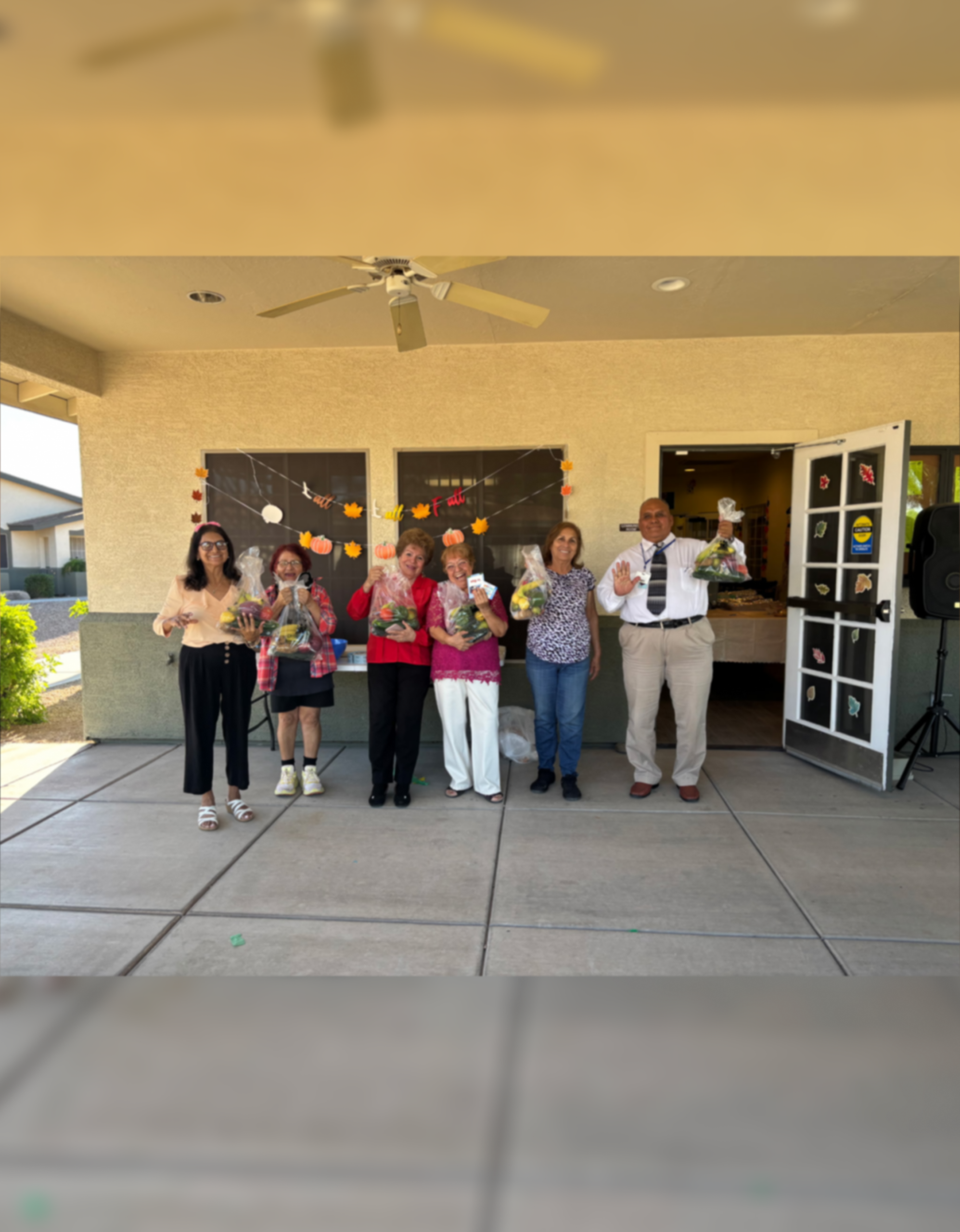 Six people holding bouquets at community celebration